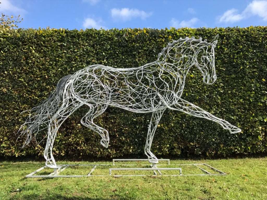 Horse Sculpture Against A Hedge