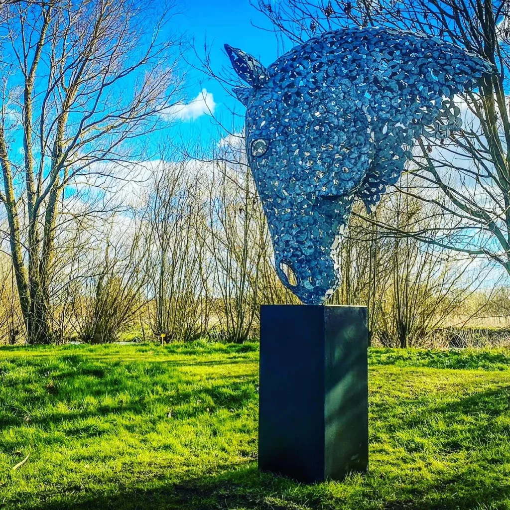 Green Horse Head Sculpture In Front Of Trees