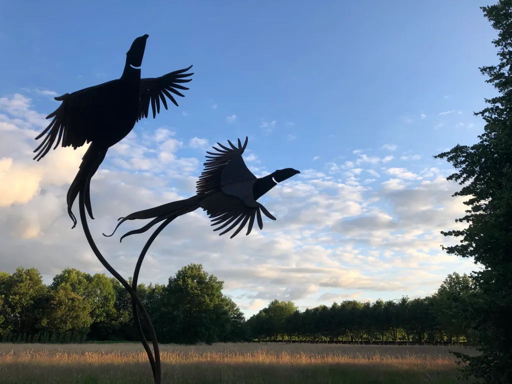 two flying black birds sculpture at dusk