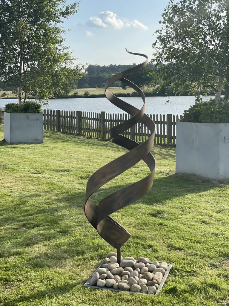 Bronze Abstract Sculpture Next To A Lake