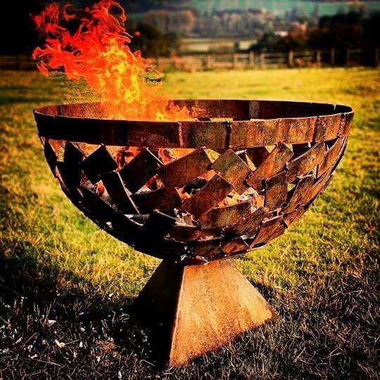 medium sized fire pit burning in field