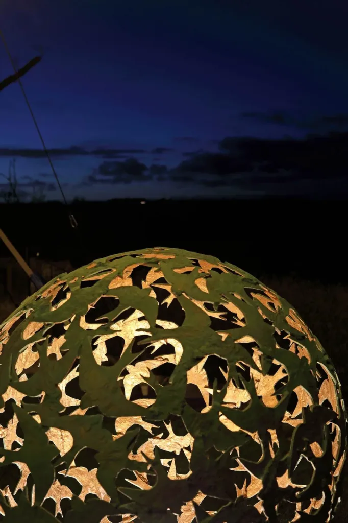 small green bird sculpture at night