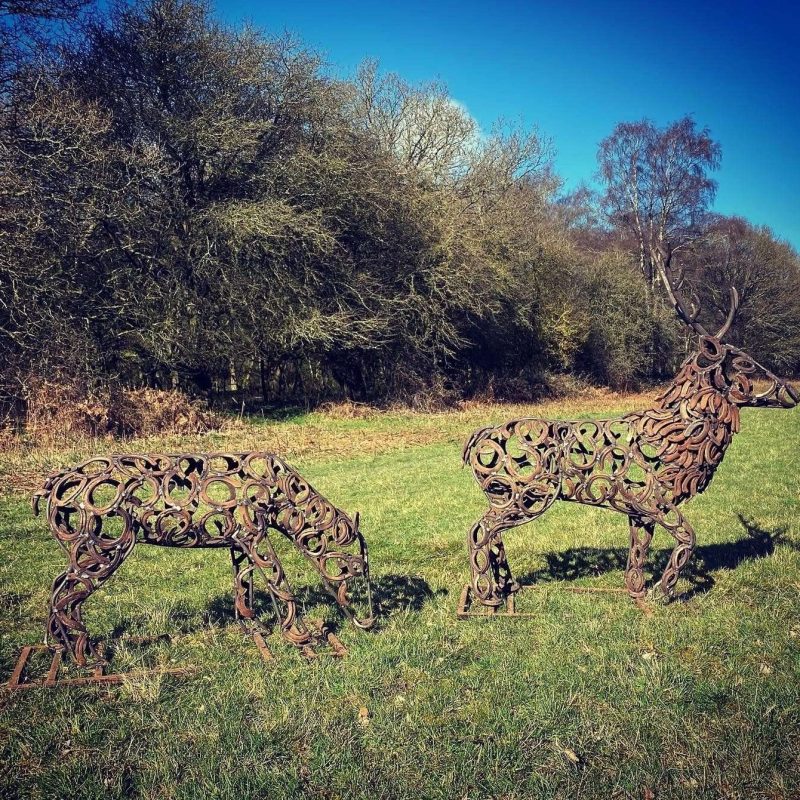 Stag and Doe Sculpture In Wooded Area