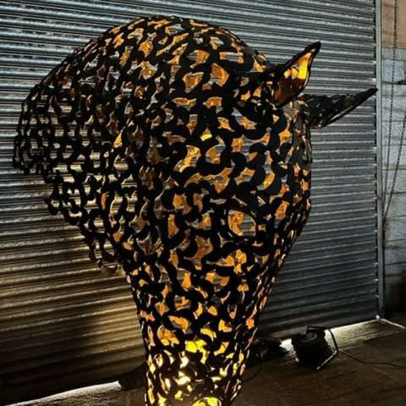 black and gold horse head sculpture lit up looking right