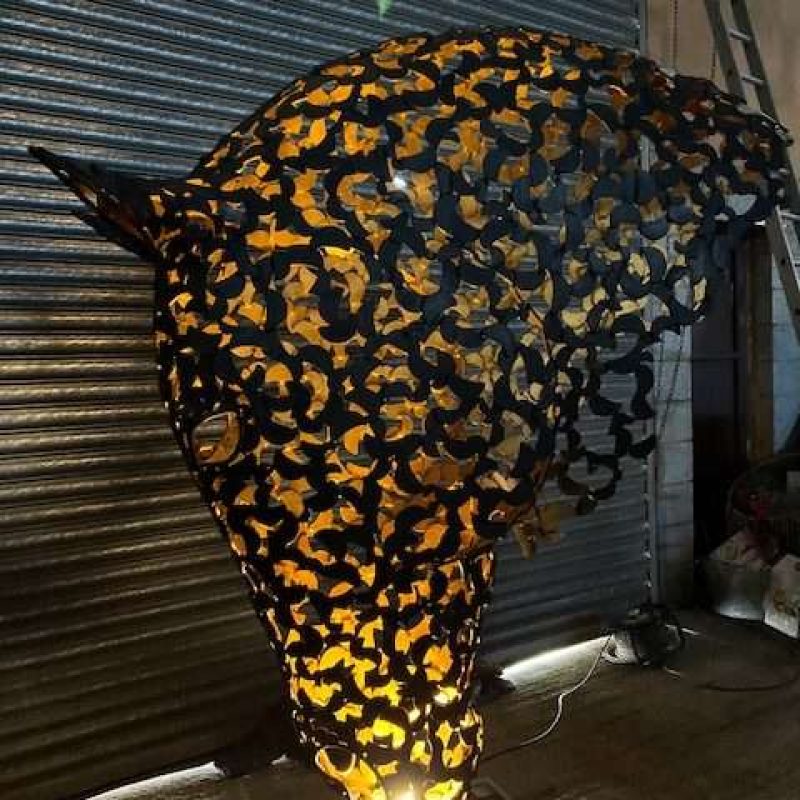 black and gold horse head sculpture lit up looking left