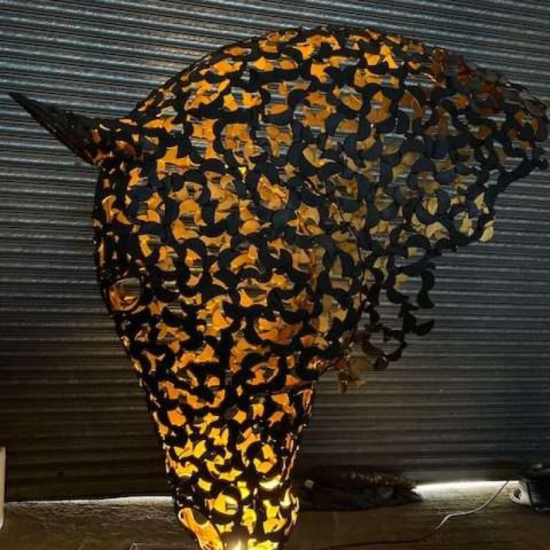black and gold horse head sculpture lit up looking left