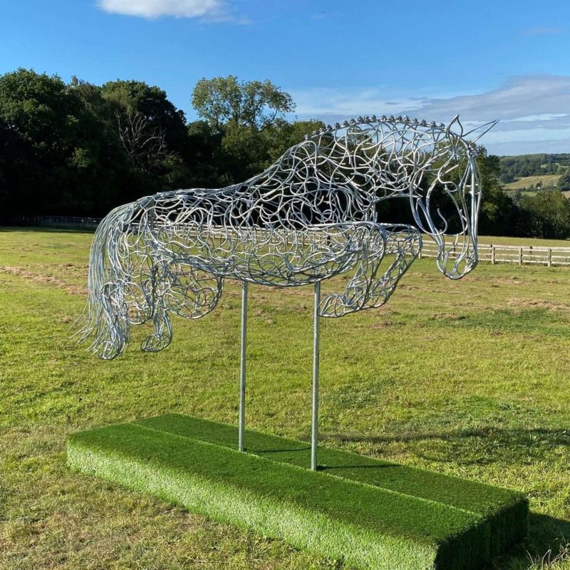 Silver Jumping Horse Sculpture On Grass Plinth