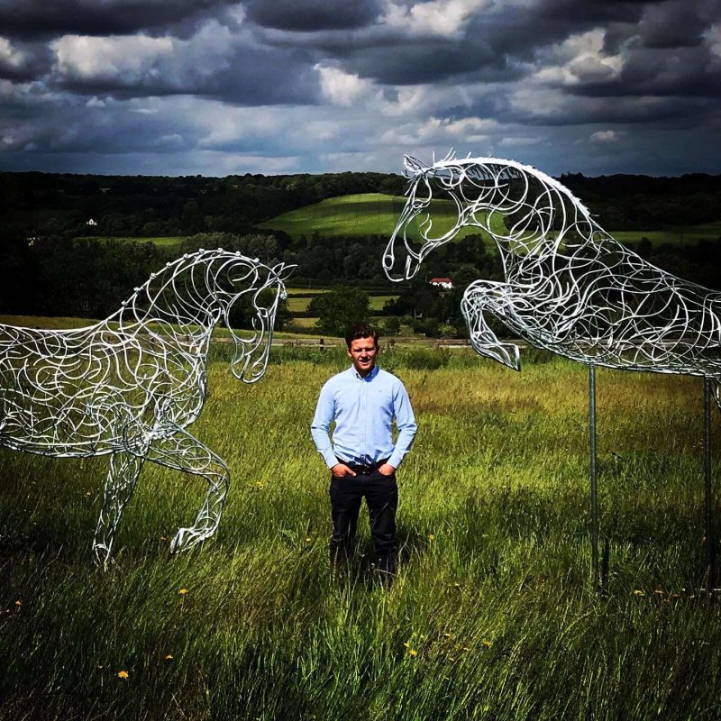 two horse sculptures with a man stood beside them